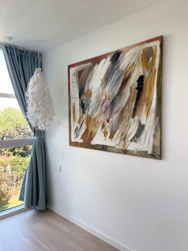 a painting hanging on a wall next to a window at Kirsebærkroen - The Inn Between in Præstø
