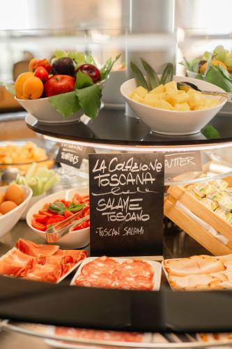 a buffet with different types of food on display at Villasanpaolo Resort & Spa in San Gimignano