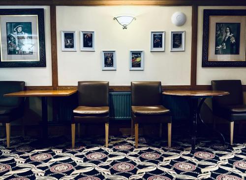 a bar with two tables and chairs and pictures on the wall at Carrington House Hotel in Bournemouth