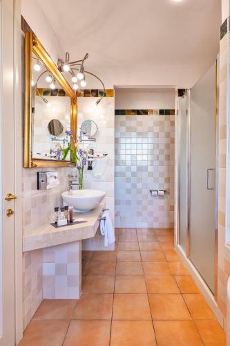 a bathroom with a sink and a mirror at Villasanpaolo Resort & Spa in San Gimignano