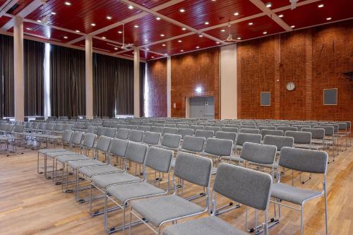 an empty lecture hall with chairs and a stage at Hotel Statt Söderhamn by First Hotels in Söderhamn