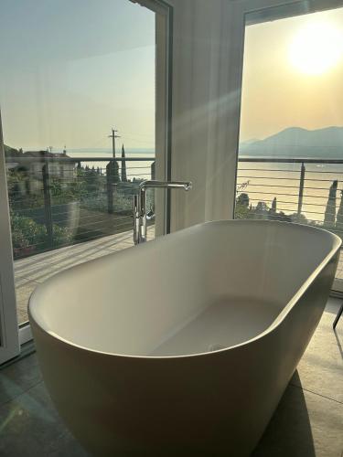 a bath tub in a bathroom with a view of the ocean at Pai 521 openspace in Torri del Benaco