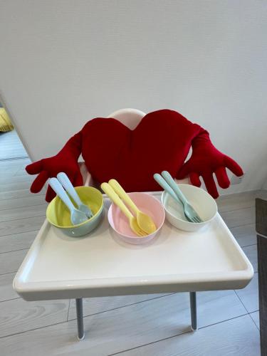 a table with three bowls and a persons hand with red gloves at 下町立石駅近民泊美幸 in Tokyo