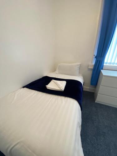 a small bedroom with a bed with a towel on it at The New ATLAS HOTEL in Blackpool