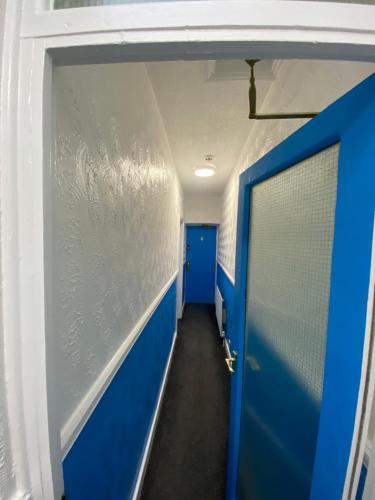 a hallway with a blue door in a room at The New ATLAS HOTEL in Blackpool