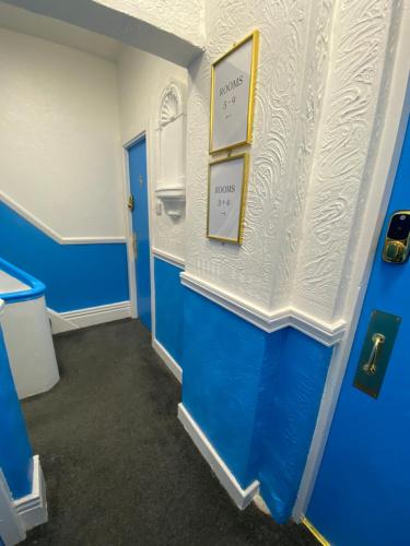 a blue and white room with two pictures on the wall at The New ATLAS HOTEL in Blackpool
