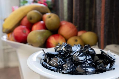 a bowl of fruit with apples and bananas on a table at Hotel Statt Söderhamn by First Hotels in Söderhamn
