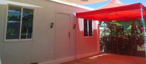 a red door of a house with a red umbrella at Bay Ellie B and B tiny home in Asturias