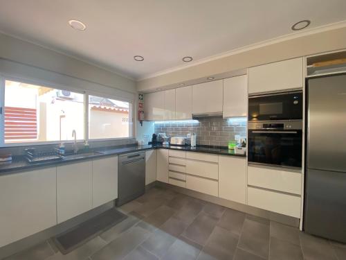 a kitchen with white cabinets and stainless steel appliances at Villa ELTAEL - Miguel House - Warm Pool from April 2026- Facilities for Disabled Guests in Manta Rota
