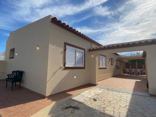 a home with a patio and a house at Villa ELTAEL - Miguel House - Warm Pool until 1 November - Facilities for disabled guests in Manta Rota