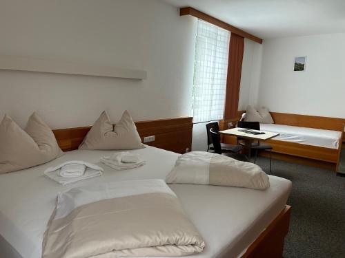 a hotel room with two beds and a desk at Villa Styria in Bad Aussee