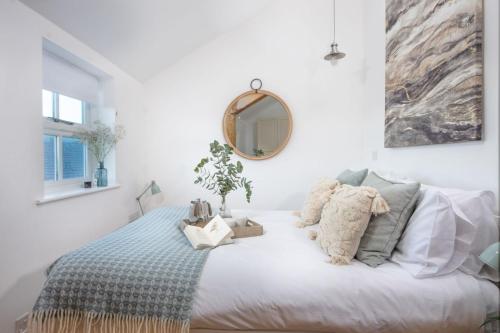 a bedroom with a bed with a mirror on the wall at Sennen Surf Loft, Sennen in Sennen