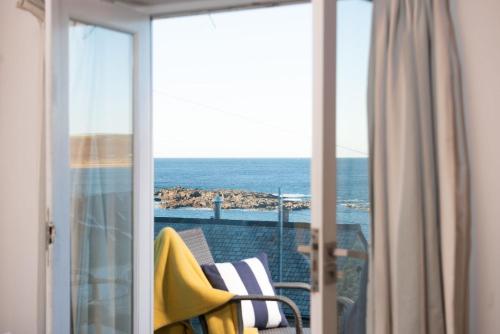 a room with a balcony with a view of the ocean at Sennen Surf Loft, Sennen in Sennen