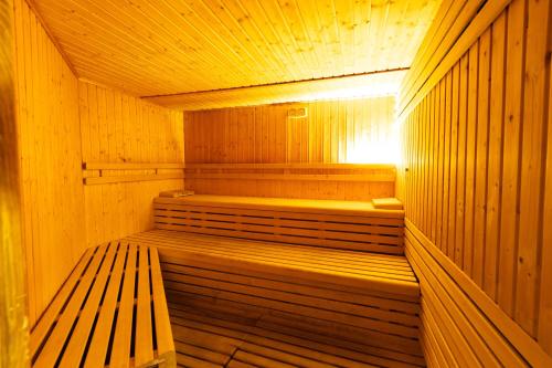 a wooden sauna with a wooden bench in it at Hotel IPV Palace & Spa - Adults Recommended in Fuengirola