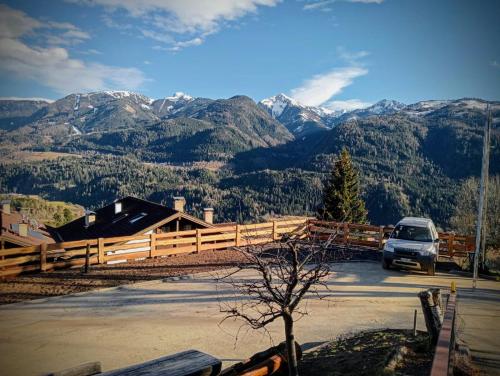 a car parked in a parking lot with mountains in the background at Pozza Appartamenti in Carano