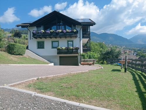 a house with a balcony with flowers on it at Pozza Appartamenti in Carano