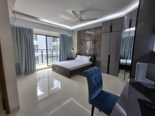 a bedroom with a bed and a desk and a chair at Elegant Secured Family Apartment with Open Space in Dhaka