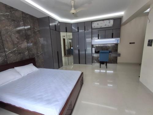 a bedroom with a large bed and a blue chair at Elegant Secured Family Apartment with Open Space in Dhaka