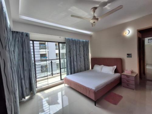 a bedroom with a bed and a large window at Elegant Secured Family Apartment with Open Space in Dhaka