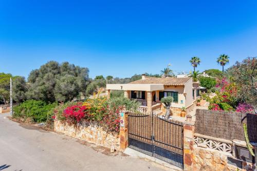 a house on the side of a road with flowers at Can Juanito by dracmallorca in Cala Llombards