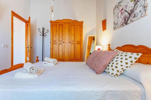 a bedroom with a bed with two towels on it at Can Juanito by dracmallorca in Cala Llombards