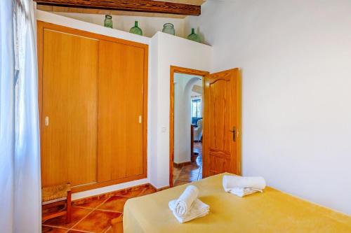 a bedroom with a bed and a wooden cabinet at Can Juanito by dracmallorca in Cala Llombards