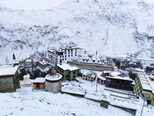 a town covered in snow with mountains in the background at Green Land Guest House Ladakh by LexStays in Lāmayūrū