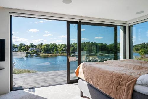 a bedroom with a bed and a view of the water at Lyxig villa i Solsidan in Stockholm