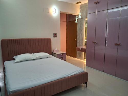 a bedroom with a bed and a purple cabinet at Elegant Secured Family Apartment with Open Space in Dhaka