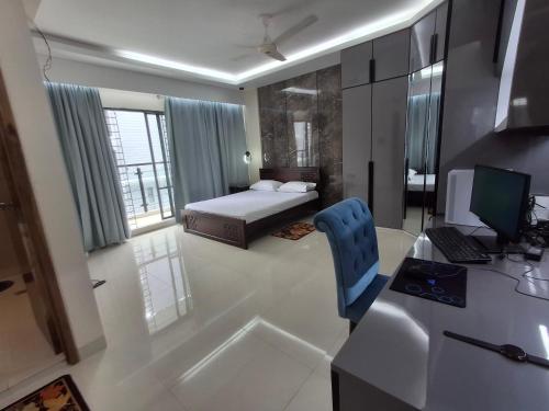 a bedroom with a bed and a desk with a computer at Elegant Secured Family Apartment with Open Space in Dhaka