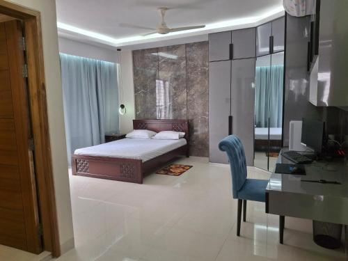 a bedroom with a bed and a desk and a chair at Elegant Secured Family Apartment with Open Space in Dhaka