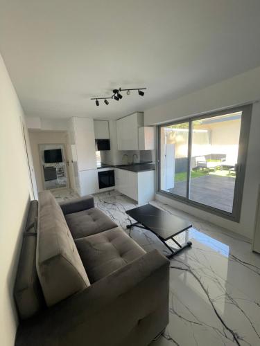 un salon avec un canapé et une grande fenêtre dans l'établissement Cannes Appartement Terrasse Parking privé, à Cannes