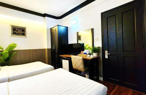 a room with two beds and a desk with a computer at Rosa Hotel & Spa in Ho Chi Minh City
