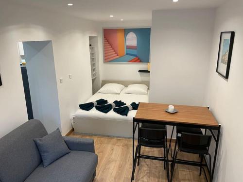 Cette chambre comprend un lit, une table et un canapé. dans l'établissement Charmant Studio au coeur de la ville, à Champigny-sur-Marne