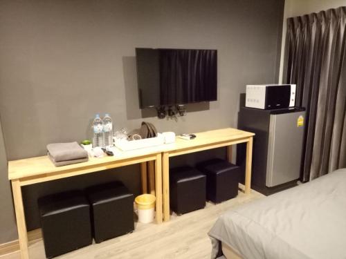 a bathroom with a sink and a desk in a room at My Home N1 - BTS Ratchathewi in Bangkok