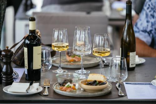 a table topped with glasses of wine and food at Strandhotel Klinten in Rødvig