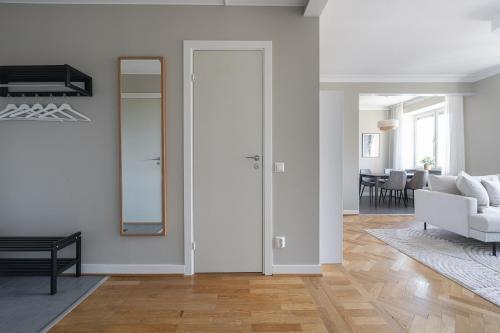 a white living room with a white couch and a mirror at Live and Stay VR40 in Gothenburg