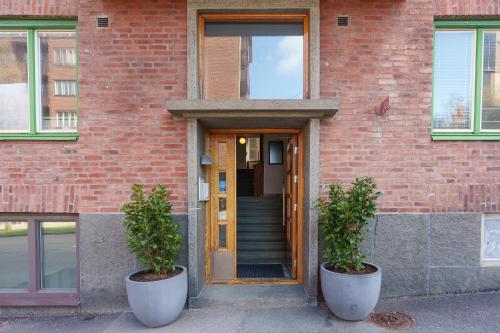two potted plants in front of a brick building at Live and Stay VR40 in Gothenburg