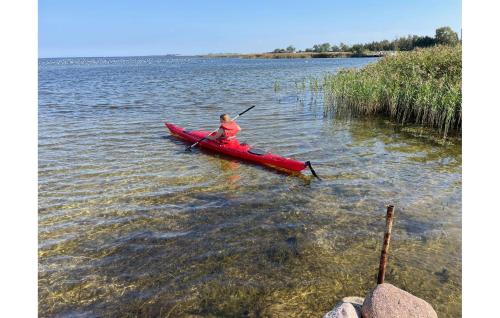 a woman in a red kayak in the water at Gorgeous Home In Mern With Wifi in Mern