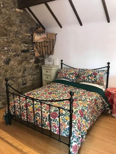 a bedroom with a bed and a stone wall at Stone Wall Cottage in Castlewellan
