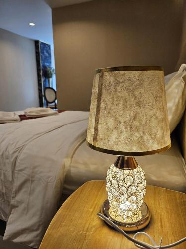 a lamp on a table next to a bed at Sam Homestay in Bangkok