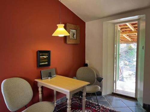 a dining room with a table with chairs and a laptop at gîte sivade - vue épique - grand jardin clôturé in Capdrot