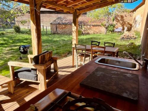 a patio with a sink and a table and a table at gîte sivade - vue épique - grand jardin clôturé in Capdrot