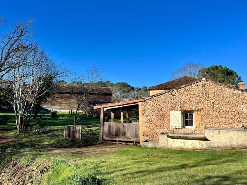 an old brick house in a field of grass at gîte sivade - vue épique - grand jardin clôturé in Capdrot