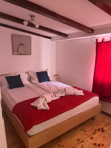 a bedroom with a large bed with a red curtain at Le Liv On in Rijeka