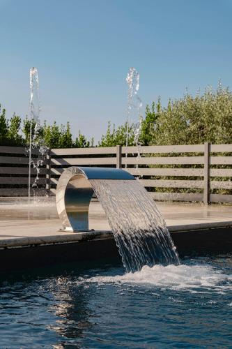 a water fountain in the middle of a pond at Villasanpaolo Resort & Spa in San Gimignano