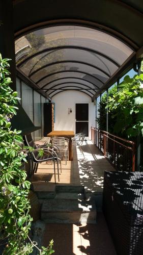 a covered porch with a table and chairs on it at BBPrimavera in Purasca