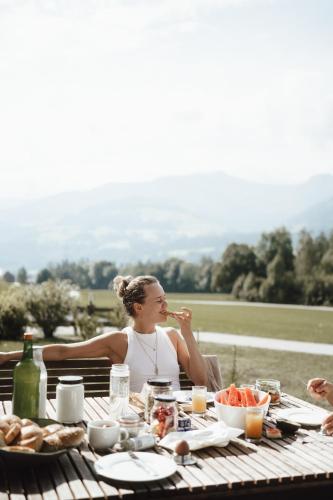 a woman sitting at a table eating food at Luxury Chalets Gradenbach near Schladming in Haus im Ennstal