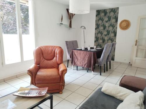 - un salon avec un fauteuil en cuir et une table dans l'établissement Le Repère - Idéal Famille ou Amis - Pau, à Pau