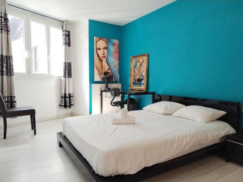 une chambre avec un grand lit avec un mur bleu dans l'établissement Le Repère - Idéal Famille ou Amis - Pau, à Pau